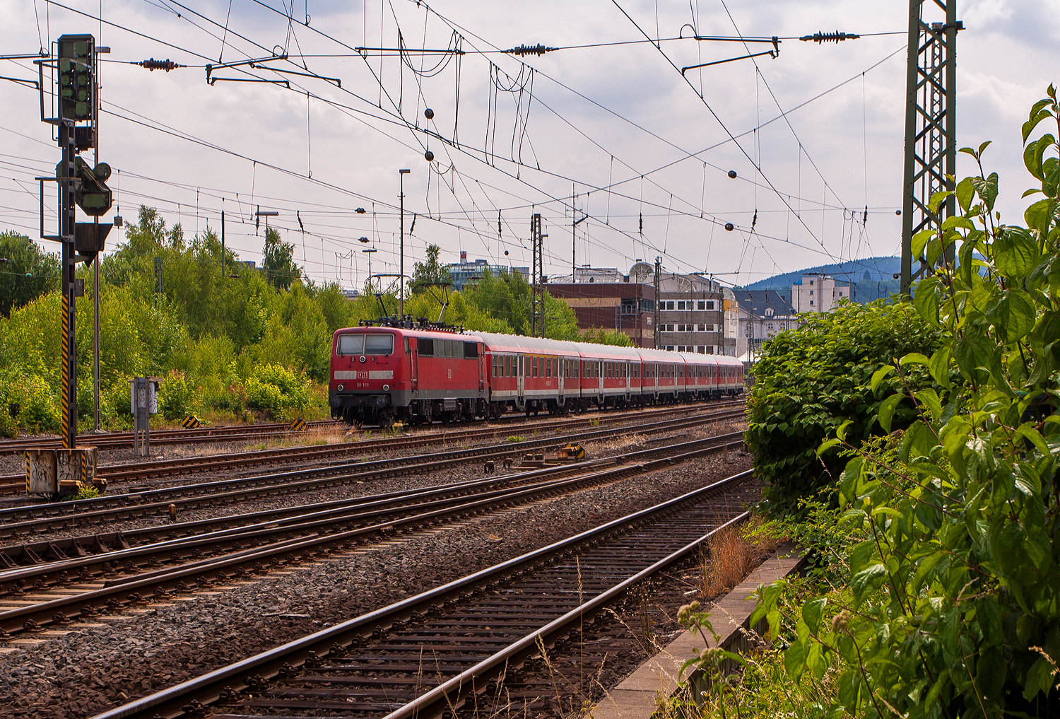 Die 111 112-9 (91 80 6111 112-9 D-DB) der DB Regio NRW ist mit fünf n-Wagen (ex Silberlinge), als Verstärkerzug für dem RE 9 - Rhein-Sieg-Express, am 14 Juli 2013 beim Hbf Siegen angestellt.

Die Lok wurde 1979 von Krauss-Maffei in München-Allach unter der Fabriknummer 19844 gebaut, die elektrische Ausrüstung von Siemens. Sie wurde als 111 112-9 an die Deutsche Bundesbahn geliefert. Im Jahr 2022 wurde sie an die TRI Train Rental GbR (Eckental-Eschenau) verkauft, wo sie nun in der schönen Farbgebung blau/schwarz unter der Betreiberbezeichnung E 11 112 (91 80 6111 112-9 D-TRAIN) fährt. Ich hoffe es sind noch einige Jahre.

Die Lok besitzt eine Konventionelle-Wendezug-Steuerung (36-poliges Kabel) und eine Zeitmultiplexe-Wendezug-Steuerung (UIC-Kabel).

