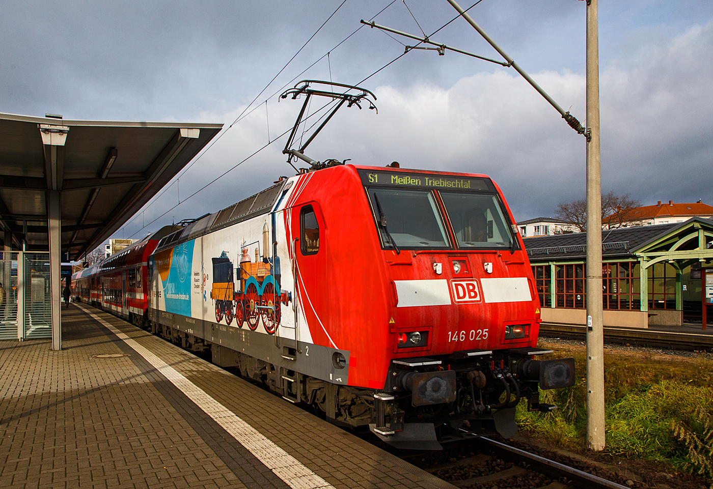 Die 146 025-2 (91 80 6146 025-2 D-DB) der DB Regio AG Südost verlässt am 07.12.2022, als S 1 der S-Bahn Dresden nach Meißen-Triebischtal, den Bahnhof Radebeul Ost.

Die TRAXX P160 AC1trägt die schöne Werbung „Was dich bewegt - Verkehrsmuseum Dresden und der SAXONIA. Die Lokomotive SAXONIA der Leipzig-Dresdner Eisenbahn-Compagnie (LDE) war die erste funktionstüchtige in Deutschland gebaute Dampflokomotive. Zum 150. Jubiläum der Eröffnung der ersten deutschen Ferneisenbahn von Leipzig nach Dresden im Jahr 1989 wurde in Eigenleistung verschiedener Dienststellen der Deutschen Reichsbahn ein betriebsfähiger Nachbau gebaut, der heute im Verkehrsmuseum Dresden museal präsentiert wird.

Die TRAXX P160 AC1 wurde 2002 von der Bombardier Transportation GmbH  in Kassel unter der Fabriknummer 33893 gebaut.