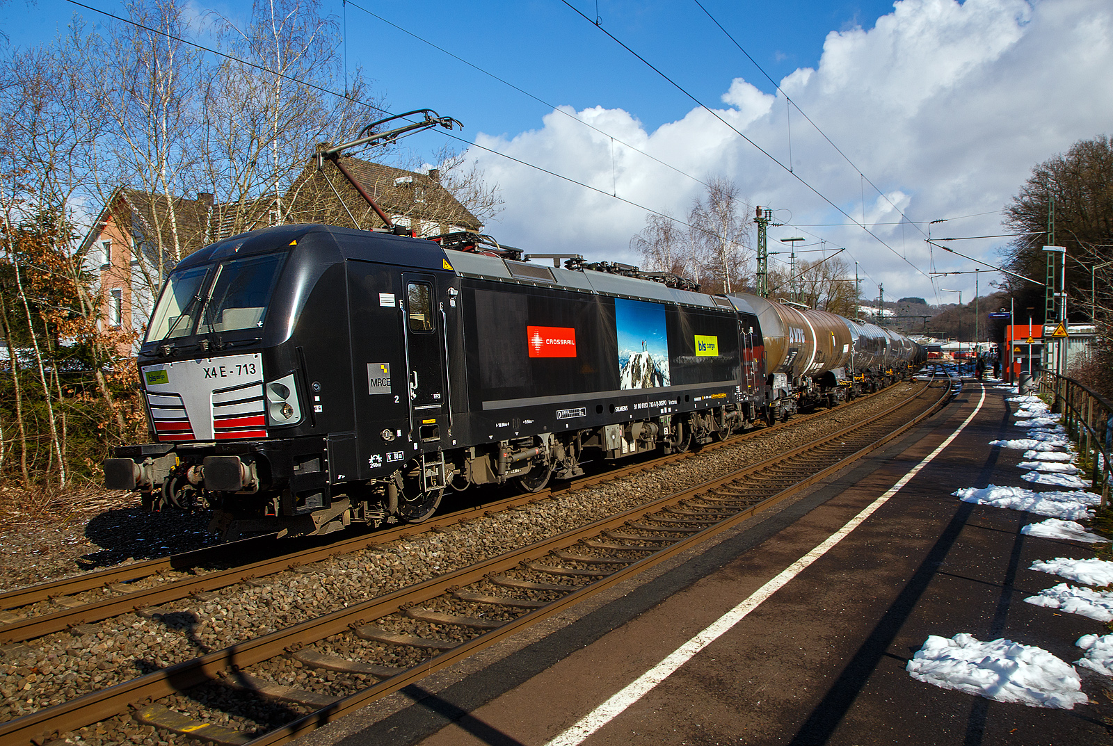 Die an die BLS Cargo / Crossrail Benelux vermietete X 4 E – 713 / 193 713-5  (91 80 6193 713-5 D-DISPO) der MRCE Dispolok GmbH (München) fährt am 15.03.2023, mit einem Kesselwagenzug durch Scheuerfeld (Sieg) in Richtung Köln. 

Die SIEMENS Vectron MS wurde 2019 von Siemens Mobilitiy in München-Allach unter der Fabriknummer 22548 gebaut. Die Vectron Lokomotive ist als MS – Lokomotive (Mehrsystemlok) mit 6.400 kW konzipiert und für 160 km/h zugelassen für Deutschland, Österreich, Schweiz, Italien und die Niederlande (D/A/CH/I/NL).