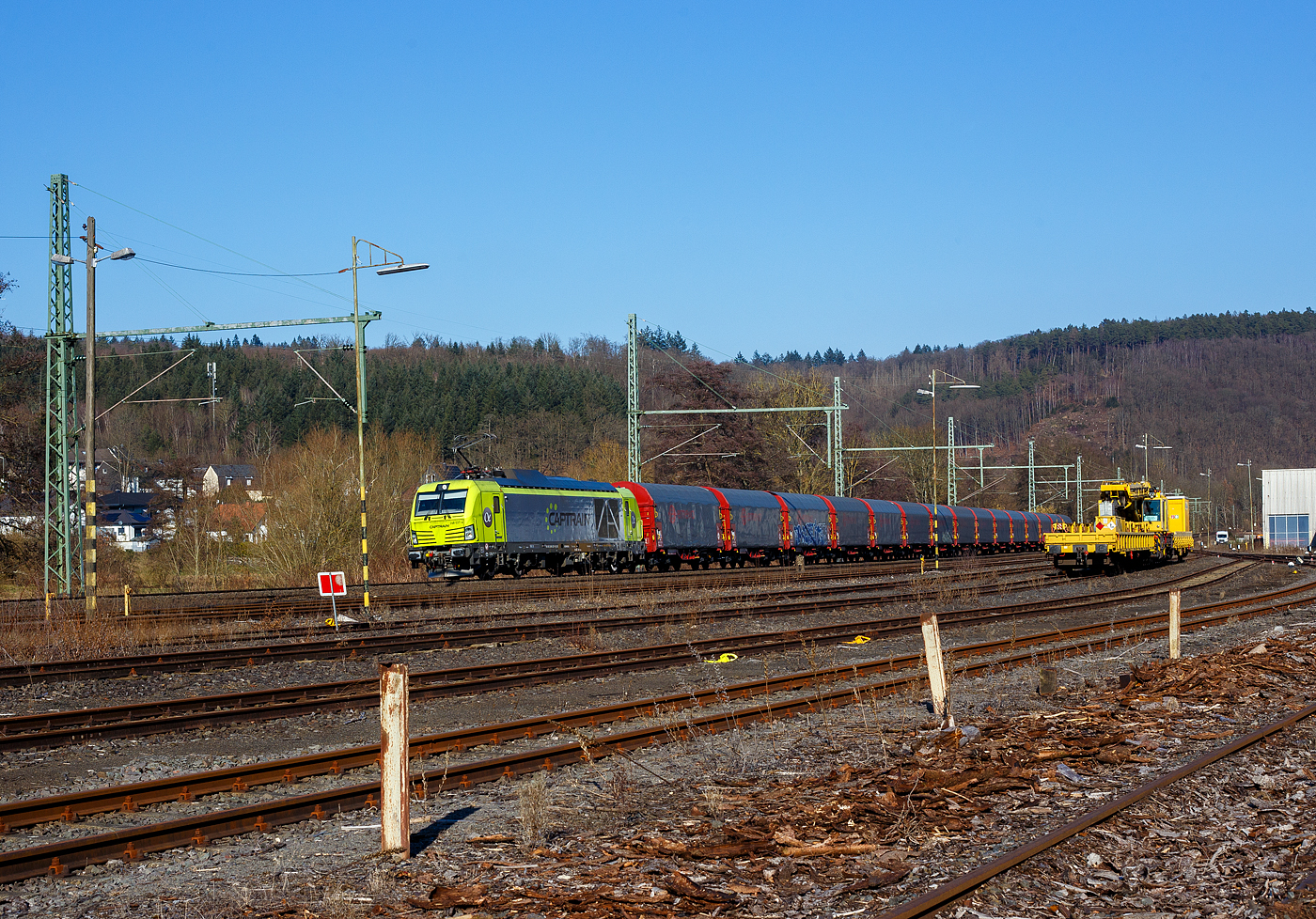 Die an die Captrain Deutschland GmbH vermietete und durch die DE - Dortmunder Eisenbahn GmbH eingesetzte SIEMENS Vectron Dual Mode 248 037-4 „Westfalen“ (90 80 2248 037-4 D-DE) der Alpha Trains Luxembourg s.à.r.l. (Luxembourg) fährt am 17 Februar 2025, mit einem Coilzug (Wagen der Gattung Shimmnis-ttu der Ermewa) durch Scheuerfeld/Sieg in Richtung Köln.

Die SIEMENS Vectron DM wurde 2022 von Siemens Mobility GmbH in München-Allach unter der Fabriknummer 23768 gebaut und an die Alpha Trains ausgeliefert. Die Lok hat die Zulassung für Deutschland und eine Höchstgeschwindigkeit von 160 km/h. Die Hybridlok (Vectron Dual Mode) kann die Antriebsenergie aus der Fahrleitung beziehen (2.400 kW Leistungen am Rad), oder mittels eines MTU 16V 4000 R84 V16-Zylinder-Dieselmotors (2.400 kW Motorleistung, 2.000 kW Leistungen am Rad) erzeugen. 

Die Dortmunder Eisenbahn GmbH (DE) ist eine private Eisenbahngesellschaft aus Dortmund. Die Dortmunder Eisenbahn GmbH ist ein gemeinsames Tochterunternehmen der Dortmunder Hafen GmbH und der Captrain Deutschland GmbH. Sie ist zu 65 Prozent im Besitz der Captrain Deutschland GmbH (deutsche Tochter der SNCF) und 35 Prozent der Anteile hält die Dortmunder Hafen AG. Die DE Infrastruktur GmbH,  mit ca. 50 Kilometern Gleislänge, gehört zu 81 Prozent der Dortmunder Hafen AG und zu 19 Prozent der Captrain Deutschland GmbH
