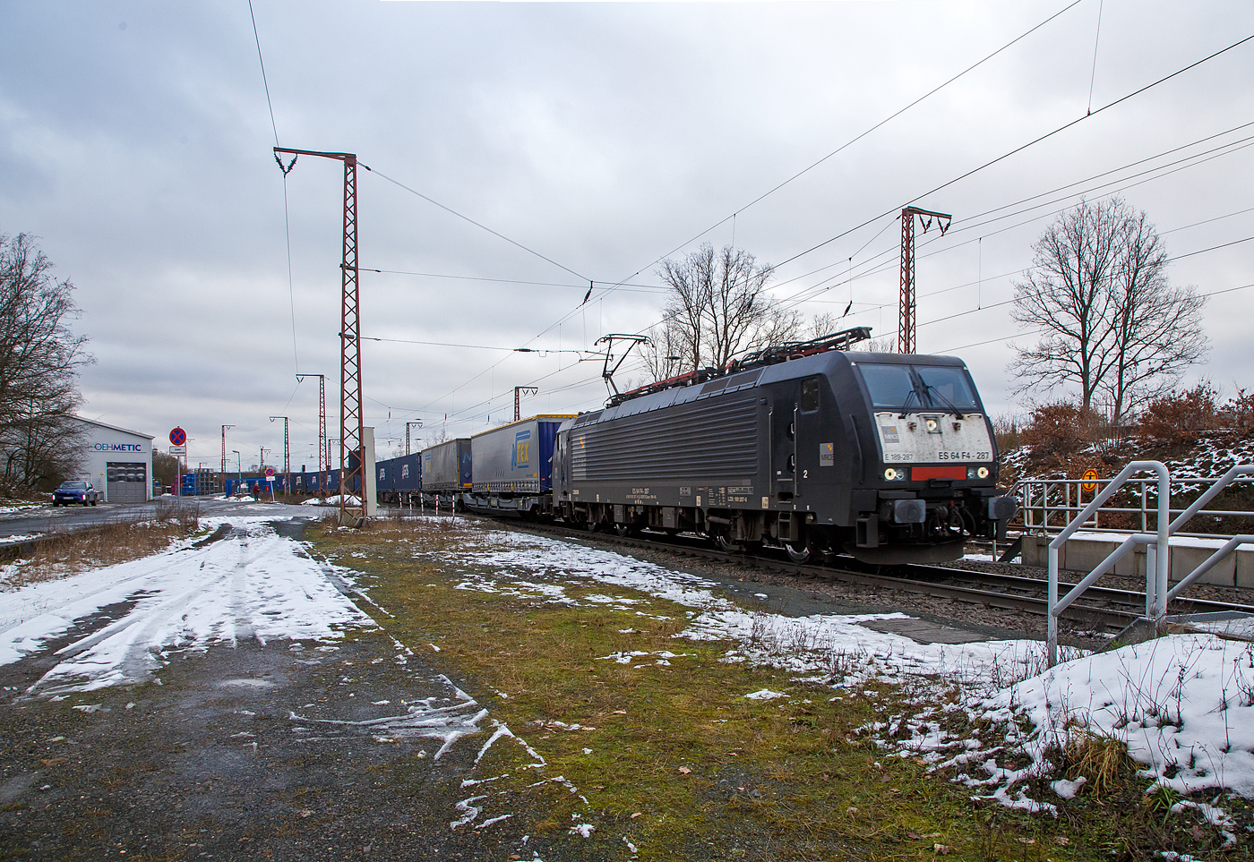 Die an die DB Cargo AG vermietete MRCE Dispolok E 189-287 bzw. ES 64 F4 - 287 / LZB 189 287-6 (91 80 6189 287-6 D-DISPO Class 189-VK) fährt am 27.01.2023 mit einem KLV-Zug durch Rudersdorf (Kr. Siegen) über die Dillstrecke (KBS 445) in südlicher Richtung. 

Die Siemens EuroSprinter wurde 2009 von Siemens in München unter der Fabriknummer 21631 gebaut. Diese Lok hat Zulassung für Deutschland, Österreich und die Niederlande.

Die BR 189 (Siemens ES64F4) hat eine Vier-Stromsystem-Ausstattung. Sie ist in allen vier in Europa üblichen Bahnstromsystemen einsetzbar. Diese hier hat die Variante K (Class 189-VK) und besitzt die Zugbeeinflussungssysteme LZB/PZB, ETCS und ATB für den Einsatz in Deutschland, Österreich und den Niederlanden.
Die Stromabnehmerbestückung ist folgende: 
Pos. 1: D, A, NL (AC)
Pos. 2: NL (DC)
Pos. 3: NL (DC)
Pos. 4: D, A, NL (AC)

TECHNISCHE DATEN:
Spurweite: 1.435 mm (Normalspur)
Achsformel: Bo’Bo’
Länge über Puffer: 19.580 mm
Achsabstand im Drehgestell:  2.900 mm
Dienstgewicht: 87 t
Stundenleitung: 6.400 kW bei 15 kV / 25 kV AC; 6.000 kW bei 3 kV DC und 3.000 kW bis 4.200 kW bei 1,5 kV DC
Anfahrzugkraft: 300 kN
Maximale Dauerzugkraft bis 84 km/h; 270 kN
Höchstgeschwindigkeit: 140 km/h
Stromsysteme: 15 kV, 16,7 Hz AC;  25 kV, 50 Hz AC; 1,5 kV und 3 kV DC