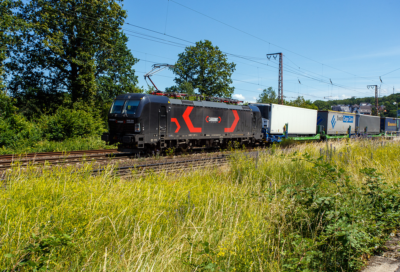 Die an die HELROM GmbH (Frankfurt am Main) vermietete SIEMENS Vectron MS 5370 069-4   CAMERON   / 6193 238 (91 51 5370 069-4 PL-ID) der CARGOUNIT Sp. z o.o. (Wrocław / Breslau) fährt am 28 Juni 2024 mit dem HELROM Trailer Zug Wien – Düsseldorf, einem besonderen KV-Zug, durch Rudersdorf (Kreis Siegen) in Richtung Siegen / Köln.

Die Siemens Vectron MS wurde 2023 von Siemens Mobility GmbH in München-Allach unter der Fabriknummer 23364 gebaut und im November 2023 an die CARGOUNIT Sp. z o.o. in Wrocław/Polen (Breslau) geliefert. Diese Vectron Lokomotive ist als MS – Lokomotive (Mehrsystemlok) mit 6.400 kW Leistung und 200 km/h Höchstgeschwindigkeit konzipiert. Hier in der Version A 10 hat sie die Zulassungen für Polen, Deutschland, Österreich, Niederlande, Slowakei, Rumänien, Ungarn und Bulgarien (PL/D/A/NL/SK/RO/H/BG). Tschechien (CZ) ist z.Z. nach durchgestrichen. Die SIEMENS Vectron MS der Version A 10 besitzt die Zugsicherungssysteme ETCS BaseLine 3, sowie
für Deutschland (PZB90 / LZB80 (CIR-ELKE I)), 
für Österreich (ETCS Level 1 mit Euroloop, ETCS Level 2, PZB90 / LZB80),
für Polen (SHP)
für Tschechien und Slowakei (LS (Mirel))
für Ungarn (ETCS Level 1, EVM (Mirel))
für Rumänien (PZB90)
und für die Niederlande (ETCS Level 1, ETCS Level 2, ATB-EGvV)

Die CARGOUNIT Sp. z o.o. in Wrocław (Breslau) / Polen wurde 2003 gegründet und stieg 2012 in das Leasinggesellschaft für Lokomotiven ein. Aktuell verfügt Cargounit über einen Fuhrpark von insgesamt 220 Lokomotiven. Das Unternehmen ist der größte Verleiher von Lokomotiven in Polen und die Nummer 5 in Europa. Ende Februar 2024 unterzeichnete CARGOUNIT mit Siemens Mobility einen Vertrag über weitere bis zu 100 Lokomotiven.
