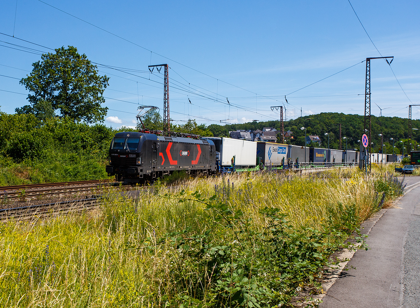 Die an die HELROM GmbH (Frankfurt am Main) vermietete SIEMENS Vectron MS 5370 069-4   CAMERON   / 6193 238 (91 51 5370 069-4 PL-ID) der CARGOUNIT Sp. z o.o. (Wrocław / Breslau) fährt am 28 Juni 2024 mit dem HELROM Trailer Zug Wien – Düsseldorf, einem besonderen KV-Zug, durch Rudersdorf (Kreis Siegen) in Richtung Siegen / Köln.

Die Siemens Vectron MS wurde 2023 von Siemens Mobility GmbH in München-Allach unter der Fabriknummer 23364 gebaut und im November 2023 an die CARGOUNIT Sp. z o.o. in Wrocław/Polen (Breslau) geliefert. Diese Vectron Lokomotive ist als MS – Lokomotive (Mehrsystemlok) mit 6.400 kW Leistung und 200 km/h Höchstgeschwindigkeit konzipiert. Hier in der Version A 10 hat sie die Zulassungen für Polen, Deutschland, Österreich, Niederlande, Slowakei, Rumänien, Ungarn und Bulgarien (PL/D/A/NL/SK/RO/H/BG). Tschechien (CZ) ist z.Z. nach durchgestrichen. Die SIEMENS Vectron MS der Version A 10 besitzt die Zugsicherungssysteme ETCS BaseLine 3, sowie
für Deutschland (PZB90 / LZB80 (CIR-ELKE I)), 
für Österreich (ETCS Level 1 mit Euroloop, ETCS Level 2, PZB90 / LZB80),
für Polen (SHP)
für Tschechien und Slowakei (LS (Mirel))
für Ungarn (ETCS Level 1, EVM (Mirel))
für Rumänien (PZB90)
und für die Niederlande (ETCS Level 1, ETCS Level 2, ATB-EGvV)

Die CARGOUNIT Sp. z o.o. in Wrocław (Breslau) / Polen wurde 2003 gegründet und stieg 2012 in das Leasinggesellschaft für Lokomotiven ein. Aktuell verfügt Cargounit über einen Fuhrpark von insgesamt 220 Lokomotiven. Das Unternehmen ist der größte Verleiher von Lokomotiven in Polen und die Nummer 5 in Europa. Ende Februar 2024 unterzeichnete CARGOUNIT mit Siemens Mobility einen Vertrag über weitere bis zu 100 Lokomotiven.