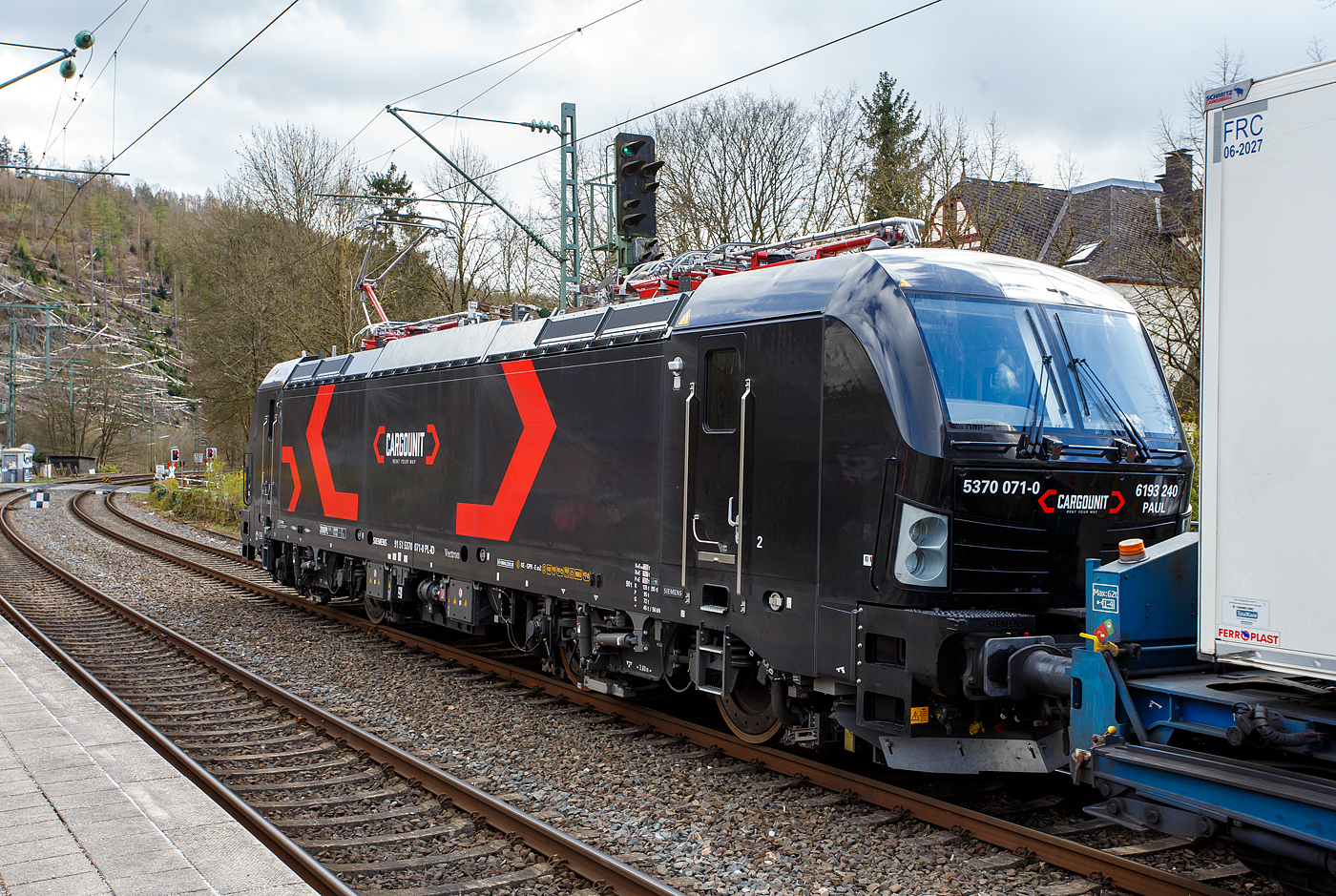 Die an die HELROM GmbH (Frankfurt am Main) vermietete Siemens Vectron MS 5370 071-0   PAUL  / 6193 240 (91 51 5370 071-0 PL-ID) der CARGOUNIT Sp. z o.o. (Wrocław / Breslau) fährt am 28 März 2024 mit dem HELROM Trailer Zug Wien – Düsseldorf, einem besonderen KV-Zug, durch Kirchen (Sieg) in Richtung Köln. Da wegen Schäden auf der folgenden Siegbrücke nur immer ein Zug fahren darf hat sie kurz im Bahnhof hier Hp 0 und muss den entgegenkommenden LINT der HLB abwarten. 

Die Siemens Vectron AC wurde 2023 von Siemens Mobility GmbH in München-Allach unter der Fabriknummer 23519 gebaut und im Januar 2024 an die CARGOUNIT Sp. z o.o. in Wrocław/Polen (Breslau) geliefert. Diese Vectron Lokomotive ist als MS – Lokomotive (Mehrsystemlok) mit 6.400 kW Leistung und 200 km/h Höchstgeschwindigkeit konzipiert. 

In der Version A 10 hat sie die Zulassungen für Polen, Deutschland, Österreich, Niederlande, Slowakei, Rumänien, Ungarn und Bulgarien (PL/D/A/NL/SK/RO/H/BG). Tschechien (CZ) ist z.Z. nach durchgestrichen.

Die CARGOUNIT Sp. z o.o. in Wrocław (Breslau) / Polen wurde 2003 gegründet und stieg 2012 in das Leasinggesellschaft für Lokomotiven ein. Aktuell verfügt Cargounit über einen Fuhrpark von insgesamt 220 Lokomotiven. Das Unternehmen ist der größte Verleiher von Lokomotiven in Polen und die Nummer 5 in Europa. Ende Februar 2024 unterzeichnete CARGOUNIT mit Siemens Mobility einen Vertrag über weitere bis zu 100 Lokomotiven.
