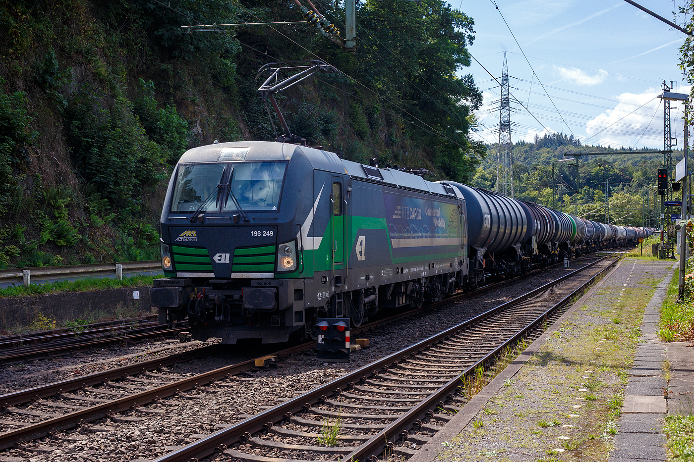 Die an die RTB CARGO GmbH (RATH Gruppe/Rurtalbahn) vermietete SIEMENS Vectron AC 193 249-0 (91 80 6193 249-0 D-ELOC) der ELL - European Locomotive Leasing (Wien) fährt am 08 August  2024 mit einem Kesselwagenzug durch Scheuerfeld/Sieg in Richtung Siegen. Sie trägt die Werbung: RTB CARGO | „Connected by Mobiltty“ | ARS Altmann

Die Wechselstromlok (AC 15 kV 16,7 Hz und AC 25 kV 50 Hz) SIEMENS Vectron AC wurde 2016 von Siemens Mobilitiy in München-Allach unter der Fabriknummer 22025 gebaut. Sie wurde in der Vectron Variante AC B02 ausgeführt und hat so die Zulassung für Deutschland, Österreich und Ungarn (D / A / H), 

So besitzt die Variante AC B02 folgende  Zugsicherungssysteme:
ETCS BaseLine 2, sowie für Deutschland (PZB90 / LZB80 (CIR-ELKE I)), für Österreich (ETCS Level 1 mit Euroloop, ETCS Level 2, PZB90 / LZB80) und für Ungarn (ETCS Level 1, EVM (Mirel)).

Laut den Gefahrgut- Warntafel 30/1202 waren die Wagen mit Dieselkraftstoff, Gas- oder Heizöl (leicht) beladen.
