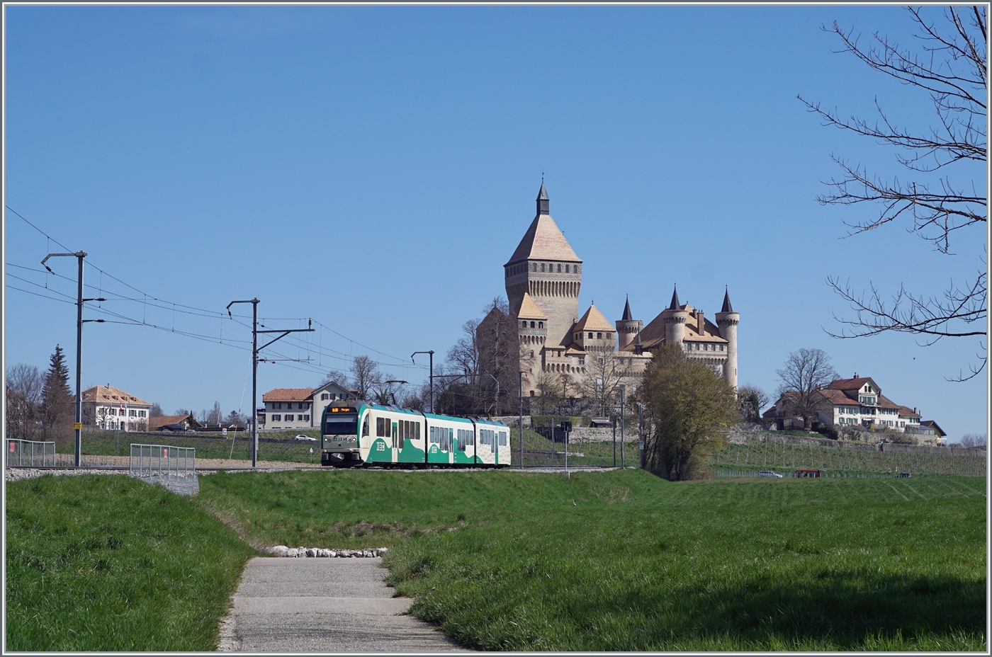 Die beiden BAM MBC Surf Be 4/4 38 und 35 mit Mittelwagen sind als Regionalzug 125 von Bier nach Morgen vor der klassischen BAM Hintergrundkulisse des Ch�teau de Vufflens unterwegs.

5. April 2023