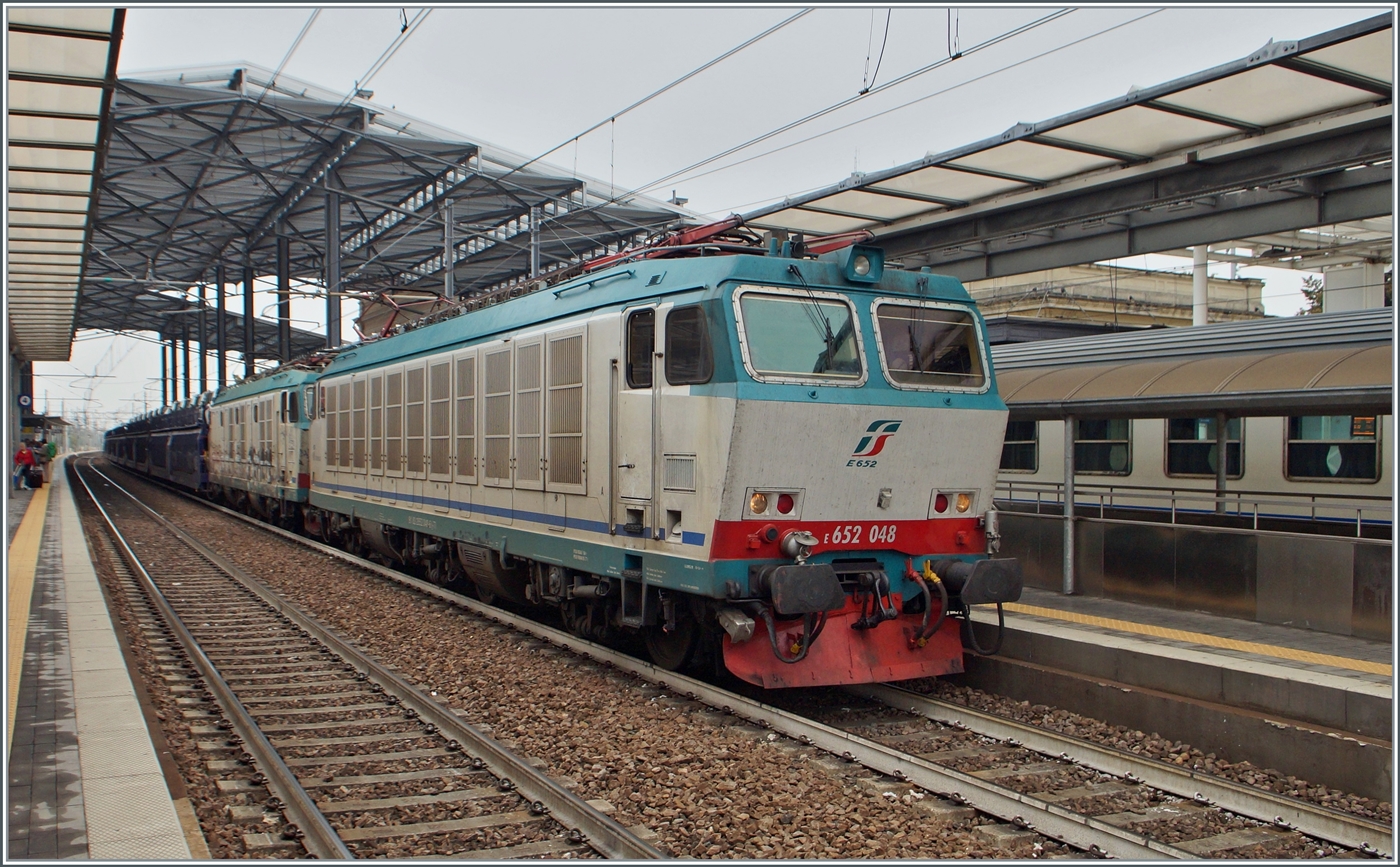 Die FS Trenitalia E 652 048 und eine weitere fahren mit einem Autoverladewagenzug durch den Bahnhof von Parma in Richtung Süden.

20. September 2014