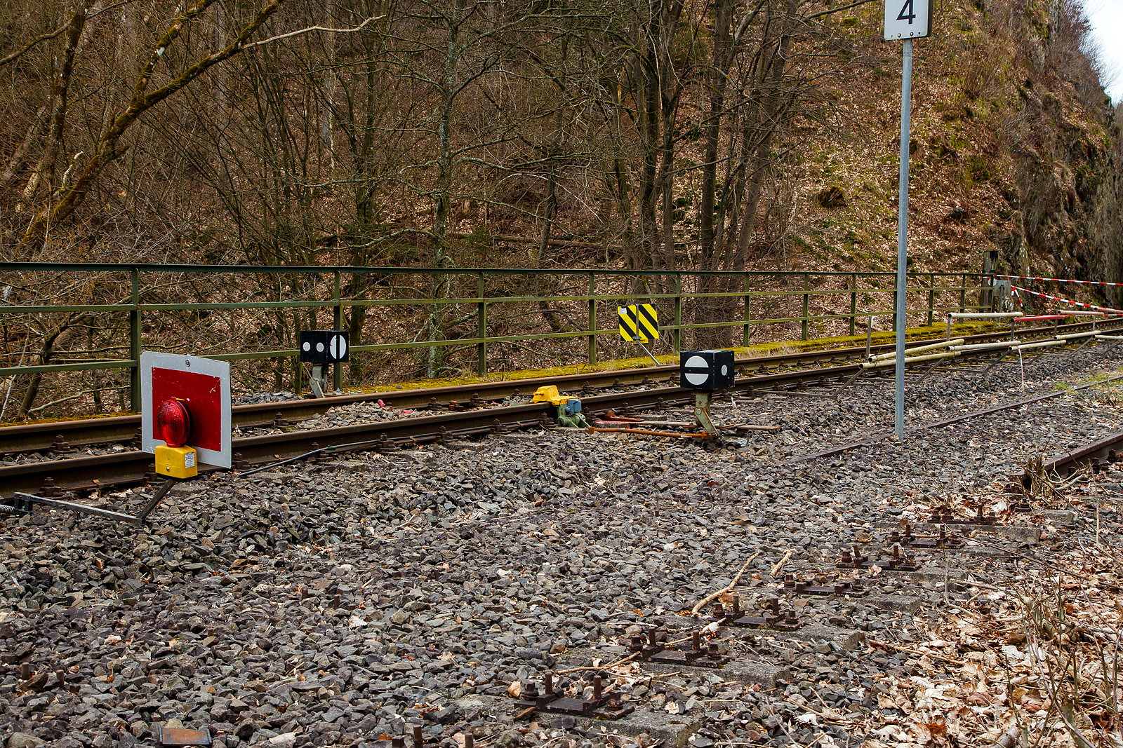 Die Hellertalbahn (KBS 462 / Strecke 2651) bei km 88,4 in Herdorf nahe dem Hp K�nigsstollen am 17.03.2023. Ab den 20.03.2023 sollen die Triebz�ge der RB 96 „Hellertalbahn“, anstelle von Neunkirchen (Siegerland), nun bis zum Hp K�nigsstollen gef�hrt werden. Der Streckenabschnitt K�nigsstollen nach Betzdorf, bleibt ja nach Felsstutz am 23.12.2022 weiter, mindestens bis zum kleinen Fahrplanwechsel im Juni 2023, gesperrt. Nun wurde hier kurz vor dem Einschnitt (der Felsstutzstelle) noch schnell eine Gleissperre gesetzt. 

F�r mich ist hier nur klappbare Entgleisungsschuh eigentlich verkehrt herum. Denn so wirkt es auf Wagen aus Betzdorf bzw. Felsstutzstelle kommend und nicht aus Richtung Herdorf zur Gefahrenstelle hin.
