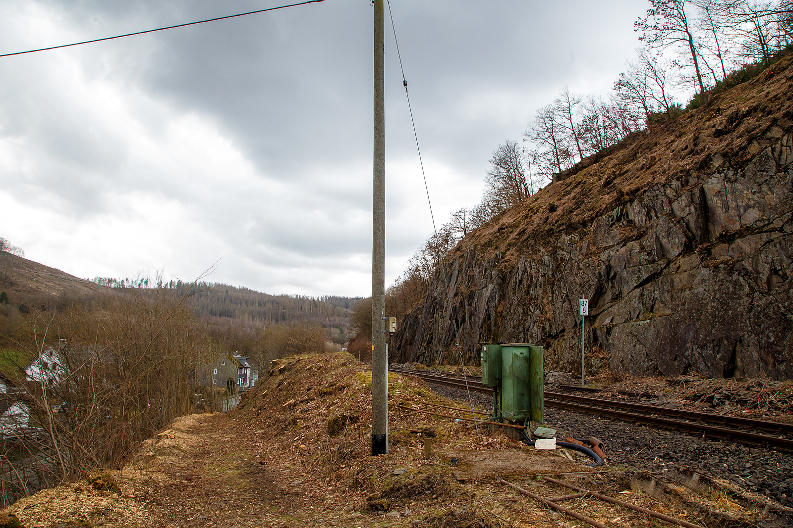 Die Hellertalbahn (KBS 462 / Strecke 2651) bei km 87,8 (bei Herdorf-Sassenroth) am 18.03.2023: Auch wenn hier min. bis zum kleinen Fahrplanwechsel im Juni 2023, wegen dem Felsstutz am 23.12.2022, kein Zug zwischen Betzdorf und dem Hp K�nigsstollen (Herdorf) f�hrt, ist und wird die Strecke nun gut freigeschnitten.

Bis 1987 war der Abschnitt Betzdorf–Herdorf noch zweigleisig, was man hier noch sehen kann.