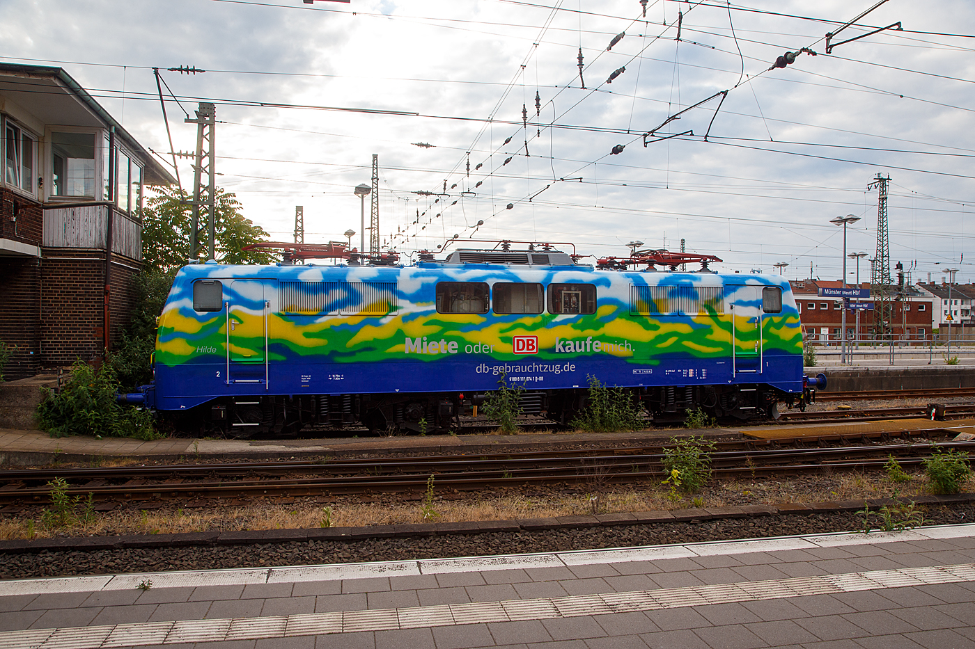 Die wundersch�ne Hilde der DB Gebrauchtzug (Miete oder kaufe misch)....
Die 111 074-1 „Hilde“ (91 80 6111 074-1 D-DB) ist am 31.05.2022 im Hauptbahnhof M�nster (Westf.) abgestellt.

Die Lok wurde 1977 von Krauss-Maffei in M�nchen-Allach unter der Fabriknummer 19832 gebaut, der elektrische Teil ist von Siemens.