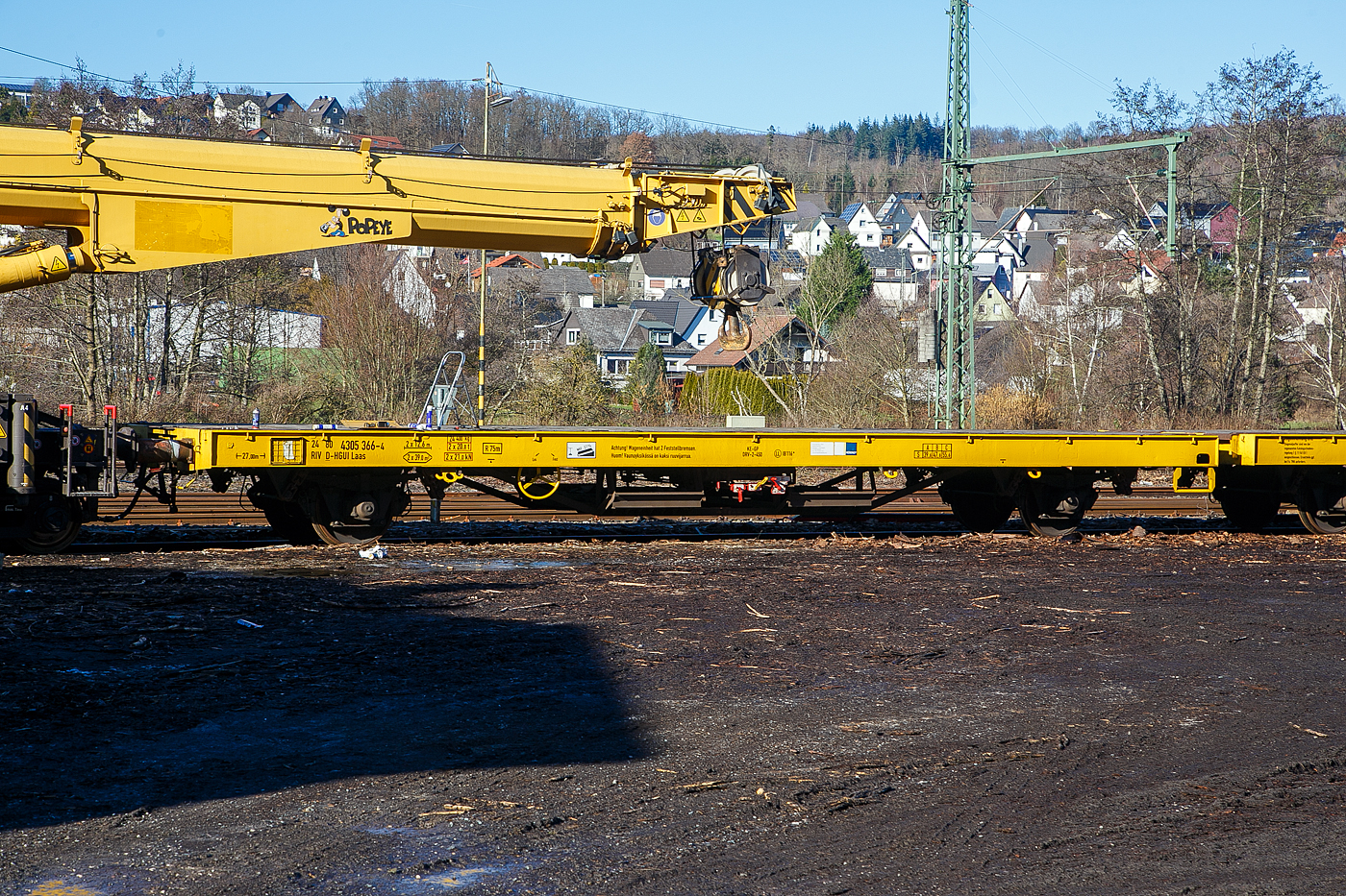 Hier nochmal die eine Einheit als Detail....
Die vierachsige Flachwageneinheit 24 80 4305 366-4 D-HGUI (ex 24 80 4305 366-5 D-TWA), der Gattung Laas, der Hering Bahnbau GmbH (Burbach) steht am 08.02.2023 beim Kleinbahnhof der WEBA in Scheuerfeld (Sieg). Der Wagen ist als Schutzwagen dem 125t - KIROW Gleisbauschienenkran KRC 810 T „Popeye“  D-HGUI 99 80 9419 010-0 zugeordnet. 
