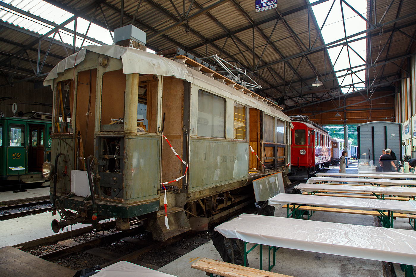 Noch in der Restaurierung (Aufarbeitungsfase) der 2./3. Klasse elektrische Personentriebwagen mit Gep�ckabteil der ehemalige Sernftalbahn SeTB  BCFe 2/2 4 der Museumsbahn Blonay–Chamby, am 27.05.2023 in der Halle der (BC) in Chaulin.

Der Personen- und Gep�cktriebwagen wurde 1928 von der SIG (Schweizerische Industrie-Gesellschaft) in Neuhausen am Rheinfall und der elektrische Teil ist von der MFO (Maschinenfabrik Oerlikon gebaut, und an die SeTB geliefert. Die Sernftalbahn (SeTB) war eine elektrische Meterspurbahn (1.000 mm) im Schweizer Kanton Glarus, sie bestand von 1905 bis 1968) und f�hrte, meist auf der Talstra�e, von Schwanden aus durch das Sernftal 13,8 Kilometer entlang des namensgebenden Flusses aufw�rts bis nach Elm. Die Triebwagen wurden mit Gleichstrom (750  V, sp�ter 800 V) aus einem eigenen Wasserkraftwerk und einer Dieselmotor-Generatoren-Gruppe angetrieben. Die Betriebsleitung befand sich in Engi in der Mitte der Strecke. Nach der Einstellung der Bahn wurde der Triebwagen, wie auch der Personenwagen BC 13 und der G�terwagen K 31, 1969 an die Museumsbahn Blonay–Chamby (BC) abgegeben.

TECHNISCHE DATEN:
Spurweite: 1.000 mm
Achsfolge: A’A’
L�nge �ber Puffer : 10.420 mm
Achsstand: 4.700 mm
Triebraddurchmesser: 860 mm (neu)
Eigengewicht: 15,2 t 
Leistung: 2 � 64 kW = 128 kW (2 x 87 PS = 174 PS)
Getriebe�bersetzungen: 1:5,92
Zul. H�chstgeschwindigkeit: 30 km/h 
Stromsystem: urspr�nglich 850 V DC (Gleichstrom) / bei der BC 1.000 V
Stromabnehmer: 1 Scheren-Stromabnehmer, Bet�tigung �ber Schnur
Max. Neigung : 68 ‰  (SeTB)
Sitzpl�tze: 6 (2. Klasse), 12 (3. Klasse) 
Gep�ckabteilgr��e: 4 m�
Max. Gep�ck Zuladungsgewicht: 3,0  t

Quellen: BC