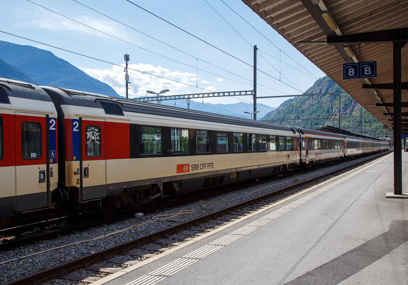 SBB EC-Gro�raum-Reisezugwagen (EC-Wagen) der zweiten Wagenklasse Bpm 61 85 20-90 331-0 CH-SBB eingereiht in einen IR 90 nach Gen�ve-A�roport (Genf Flughafen) am 07 September 2021 im Bahnhof Brig. 

Die SBB EuroCity-Wagen (Apm EC und Bpm EC) sind zwar nach �hnlichen Prinzipien aufgebaut worden, werden aber in der Schweiz nicht als Einheitswagen bezeichnet. Konstruktiv zur gleichen Gruppe geh�ren die Bt IC, die mit den EW IV eingesetzt werden und lediglich eine Einspannungsausr�stung (f�r 1000 V, 16,7 Hz) aufweisen.

1989–1995 stellten die SBB eine weitere Gro�raumwagen Serie f�r den EuroCity-Verkehr in den Dienst, die auf den 1980 abgelieferten Bpm RIC und dem EW IV aufbaute. F�r beide Wagenklassen wurde der gleiche Wagenkasten mit zehn Fenstern zwischen den Schwenkschiebet�ren an den Wagenenden benutzt. Das Dach war von der gleichen Bauart wie beim franz�sischen Corailwagen, die L�ngssicken waren aber schon bei den Einheitswagen I bis IV vorhanden. Die Sch�rzen wurden tiefer gezogen als beim EW IV, so wie es f�r den EW V vorgesehen war. In den Abmessungen entsprechen die Wagen dem UIC-Z1-Standard. Die Farbgebung in zwei Graut�nen mit hellem Streifen dazwischen wurde zuvor bereits f�r die zu zweiklassigen EuroCity-Z�gen umgebauten TEE-Z�ge (RABe) angewendet. Der helle Streifen des Eurofima-Anstrichschemas wurde beibehalten. Der Bereich �ber dem wei�en Begleitstreifen war nun in Umbragrau gehalten, darunter im helleren Verkehrsgrau A (RAL 7042). Die 60 Sitzpl�tze der ersten und 76 der zweiten Klasse sind durchgehend in Vis-�-vis-Anordnung gehalten.

Diese Wagen sind voll RIC-f�hig und f�r eine H�chstgeschwindigkeit von 200 km/h zugelassen. Insgesamt wurden 70 Apm und 155 Bpm geliefert.

TECHNISCHE DATEN:
Spurweite: 1.435 mm (Normalspur)
L�nge �ber Puffer: 26.400mm 
Drehzapfenabstand: 18.600 mm
H�chstgeschwindigkeit: 200 km/h
Eigengewicht: 45 t
Bremse: Frein O-PR+Mg (D)
Sitzpl�tze: 76 in der 1. Klasse
Rollstuhlpl�tze: 2 bis 3
Fahrradpl�tze: 2
Toilette: 1 rollstuhlg�ngige Toiletten (geschlossenes Systeme/ Vakuumsystem)
Zulassung: RIC / Schweiz LBT / NBS
Letzte Revision:  R3 war am 02.10.2018
