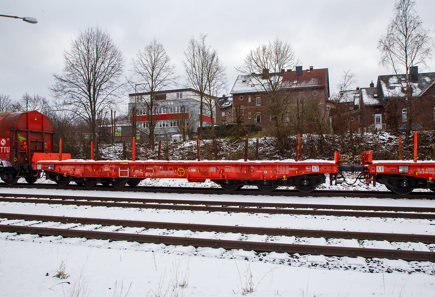 Sechsachsiger Drehgestell-Flachwagen, mit Rungen, Stirnwandklappen und klappbaren Ladeschwellen, jedoch ohne Seitenwandklappen, 31 80 4852 873-7 D-DB, der Gattung Samms 489.1, der DB Cargo AG, abgestellt am 23.01.2013  im Zugverband, auf dem KSW Rbf in Herdorf (Betriebsstätte Freien Grunder Eisenbahn - NE 447).

Der Wagen wurde 2018 von Tatravagonka a.s. in Poprad (Slowakei) gebaut. Zusammen mit Stahlkunden entwickelt die DB Schenker im Jahre 2007 einen neuen Flachwagen, der auf die Bedürfnisse der Branche noch besser eingeht. Gebaut wurden sie von dem slowakischen Hersteller Tatravagonka Poprad.

Der Wagen dient mit aufgeklappten Ladeschwellen zur Beförderung von schweren Walzprofilen und anderen sperrigen Gütern. Mit eingeklappten Ladeschwellen, also mit ebener Ladeebene, eignet er sich auch zum Transport schwerer Kettenfahrzeuge. Für das Be- und Entladen solcher Fahrzeuge sind befahrbare Stirnwandklappen vorhanden. Die Wagenbrücke ist eine in Rahmenbauweise ausgeführte Schweißkonstruktion, deren Hauptbauteile aus S355J2 (St 52) bestehen. Die Hauptbelastungen werden von den äußeren Langträgern aufgenommen. Das Kopfstück und Untergestell sind so ausgebildet, dass später ohne große Änderungen die AK eingebaut werden kann. Der Fußboden besteht aus Kiefernbohlen mit den Abmessungen 70 x 200 mm; er kann eine Radlast von 5,0 t aufnehmen. Im Fußboden sind 6 geteilte klappbare Ladeschwellen eingebaut, ebenso 6 Zurrpunkte je Längsseite. An den Außenlangträgern sind 26 Bindeösen angebracht.

Das Fahrzeug hat auf jeder Längsseite 6 Einsteckrungen und 6 zusätzliche Rungenschächte, wodurch eine variable Platzierung der Rungen ermöglicht wird (anders als bei den Vorgänger-Modellen). An jeder Stirnseite gibt es je 2 versenkbare Rungen (Fallrungen). Die Stirnwände sind umklappbar.

Durch den Einsatz der Kunststoff-Bremssohle (Cosind 810) fährt der Wagen lärmreduziert.

Hier bei der Gattung Samms 489.1 sind das Eigengewicht und die Lastgrenzen gegenüber der Gattung  Samms 489 etwas anders, so hat der Wagen eine bauartspezifische Tragfähigkeit von 104,0 t (1,5 t geringer als 489).

TECHNISCHE DATEN:
Gattung: Samms 489.1 (Gattungskennzahl 4852)
Spurweite: 1.435 mm (Normalspur)
Länge über Puffer: 16.400 mm
Drehzapfenabstand: 9.150 mm
Radsatzstand in den Drehgestellen: 2 x 1.700 mm = 3.400 mm
Raddurchmesser: 920 mm (neu)
Drehgestell-Typ: BA 714.3
Ladelänge: 15.000 mm
Ladebreite: 2.630 mm (zwischen den Rungen)
Fußbodenhöhe über SO: 1.300 mm
Ladefläche: 46 m²
Eigengewicht: 31.000 kg
Zuladung bei Lastgrenze S: 74,0 t (ab Streckenklasse D2)
Zuladung auf DB Netz bei Streckenklasse CE/D: 89,0 t (max.100 km/h)
Max. Zuladung: 104 t (bauartspezifische Tragfähigkeit)
Max. Geschwindigkeit: 100 km/h (beladen) / 120 km/h (leer)
Kleinster Gleisbogenhalbmesser: 75 m
Bauart der Bremse: KE-GP-A (K) max. 88 t
Bremssohle: Cosid 810
Handbremse: Ja
Internationale Verwendungsfähigkeit: TEN-GE
