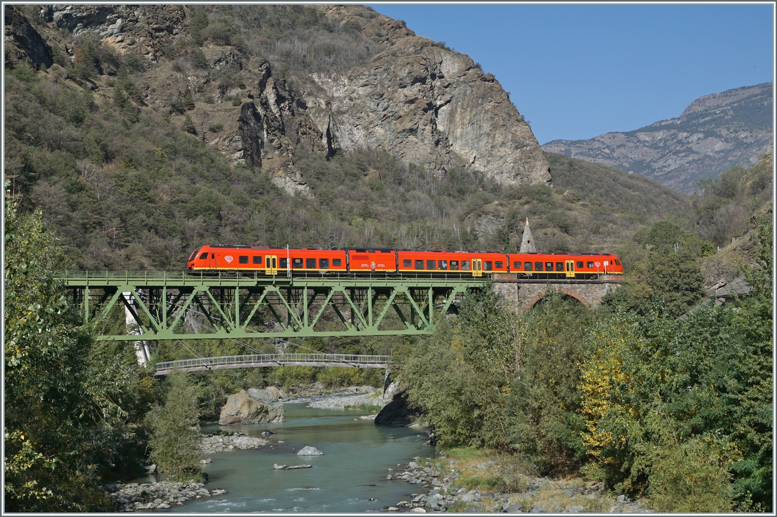 Sozusagen zwischen dem Mont Blanc und dem Matterhorn liegt das Aostatal und dort ist etwa auf halbem Weg zwischen Chatillon Saint Vincent und Verres ein bimodularer FS Trenitalia BUM BTR 813 als RV VdA 2722 von Aosta nach Torino Porta Nuova nach Aosta unterwegs und überquert bei Borgo den Fluss Dora Baltea. Die Brücke vor gut einem Monat entdeckt, fand ich dann bei der Suche nach einer Fotostelle rasch die Möglichkeit, am Ortsrand das kleinen Dorfes von Borgo eine Stelle zu finden. Erst vor Ort aber zeigte sich, dass die Vegetation weit mehr zugelegt hatte als mir lieb war und ich meine Fotostelle etwas Süden auf eine Brücke verlegen musste. Was das Bild nicht zeigt ist links ein Wasserkraftwerg und rechts die Autobahn.

11. Oktober 2023