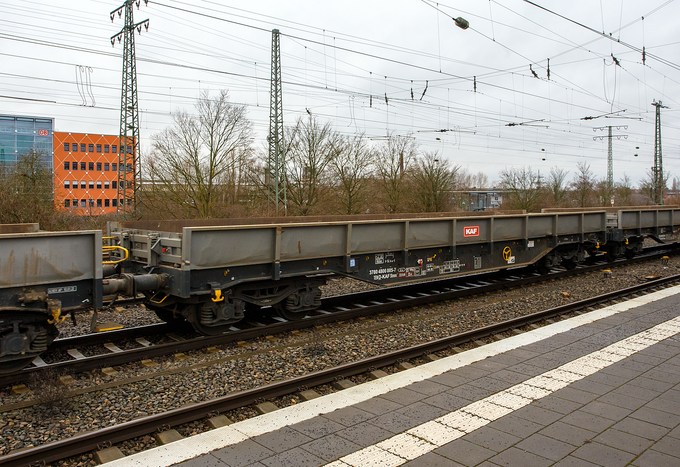Vierachsiger Drehgestell-Flachwagen, mit festen Seitenwänden und Stirnwandklappen, 37 80 4806 005-7 D-KAF, der Gattung Slmns1, der KAF - Falkenhahn Bau AG (Kreuztal) , am 14 Februar 2024 im Zugverband (mit der FAF 271 006-9 „Julius“) bei einer Zugdurchfahrt beim Hauptbahnhof Hamm (Westfalen).

TECHNISCHE DATEN:
Spurweite: 1.435 mm (Normalspur)
Gattung/Bauart: Slmns1
Anzahl der Achsen: 4 in 2 Drehgestellen
Länge über Puffer: 16.740 mm
Drehzapfenabstand:  11.700 mm
Achsabstand in den Drehgestellen: 1.800 mm
Eigengewicht: 23.900 kg
Ladelänge: 15.500 mm
Ladefläche: 43,3 m²
Maximale Ladegewicht: 66,1 t (Streckenklasse D)
Höchstgeschwindigkeit: 100 km/h (beladen) / 120 km/h (leer)
Kleinster befahrbarer Gleisbogenhalbmesser: R 45 m
Feststellbremse: ja
Bauart der Bremse: KE-GP-A (K),  Max. 58 t
Bremssohle: C 810
Intern. Verwendungsfähigkeit:  TEN-GE

Bedeutung der Gattungsbezeichnung (Slmns) :
S = Flachwagen mit Drehgestellen in Sonderbauart
l = ohne Rungen
m = mit vier Radsätzen,  Ladelänge 15 m bis unter 18 m
n = mit vier Radsätzen höchste Lastgrenze über 60
s  = lauffähig (beladen) bis 100 km/h

Quelle: laut Anschriften