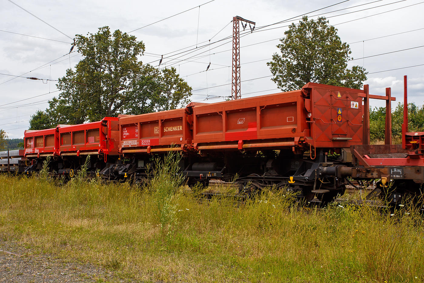 Zwei vierachsige zweimuldige Drehgestell-Schüttgutkippwagen mit elektrohydraulischer Betätigung, der Gattung Fans 128, der DB Cargo Deutschland AG, am 19 Juli 2024 im Zugverband bei einer Zugdurchfahrt durch Rudersdorf (Kreis Siegen). Vorne der Wagen 31 80 6770 569-5 D-DB (ohne Feststellbremse) und dahinter der 31 80 6770 102-5 D-DB (mit Feststellbremse).

Der zweimuldige Drehgestell-Schüttgutkippwagen (Zweiseiten-Kastenkipper) ist für den Transport von feuchtigkeitsunempfindlichen Schüttgütern wie z.B. Splitt, Kies, Schotter, erdfeuchtem Sand, Bodenaushub oder Bauschutt vorgesehen. Der Wagen besitzt einen elektrohydraulischen Kippantrieb und eine speicherprogrammierbare Steuerung (SPS). Entwickelt und in Serie gebaut wurde der Kastenkipper vom FEW Fahrzeug- und Entwicklungswerk Blankenburg (Harz) der DB AG. Die Drehgestelle liefert das Werk Halle, die Wagenkästen fertigen das Werk Kaiserlautern und DWA Niesky.

Für den Einsatz als Einzelwagen, in Wagengruppen oder beim Massenschüttgut-Transport in Ganzzügen besitzt er eine autarke Wagentechnik, die eine von äußeren Energiequellen unabhängige Entladung ermöglicht. Das Schüttgut kann als Nah- oder Weitablage abgegeben werden. Das Schüttgut beiden Seiten gekippt werden. Der Wagen verfügt über zwei getrennt kippbare Mulden. Die Wagen haben eine Batterie die über Achsgeneratoren (hier im Bild an der 2. Achse von rechts) aufgeladen werden.

TENISCHE DATEN:
Erstes Lieferjahr: 1996
Spurweite: 1.435 mm (Normalspur)
Länge über Puffer: 11.600 mm
Drehzapfenabstand: 6.580 mm
Achsabstand im Drehgestell: 1.800 mm
Drehgestell-Bauart: Y 25 Lsd 1 - 629
Laufraddurchmesser: 920 mm (neu)
Laderaum: 2 x 18,0 m³
Ladefläche: 2 × 12,0 m²
Höhe der Beladeöffnung: 3.512 mm
Kippwinkel des Kastens: 45°
Kippantrieb Energieversorgung: autark, über Batterie geladen über Achsgenerator
Kippantrieb Kapazitätsverbrauch pro Entladung: 5 bis 10 (Ah)
Kippbewegungen: über zwei Hydraulikzylinder je Kasten
Höchstgeschwindigkeit: 120 km/h (leer) / 100 km/h (beladen)
Eigengewicht: 29.400 bzw. 29.300 kg
Maximales Ladegewicht: 60,5 t (ab Streckenklasse D4), oder DB CM4 54,5 t
Kleinster bef. Gleisbogenradius: 75 m
Bremse: KE-GP-A (LL)
Bremssohle: IP 116
Intern. Verwendungsfähigkeit: RIV

Der Wagen ist zum Transport von witterungsunempfindlichem Schüttgut (mit einer max. Kantenlänge von 40 cm). Der Aufbau besteht aus zwei einzeln kippbaren Kästen mit einem Fassungsvermögen von je 18 m³, die wahlweise nach rechts oder links gekippt werden können. Dabei besteht die Möglichkeit, die Abwurfweite in zwei Stufen zu variieren; „nah“ für die Tiefbunkerentleerung und „weit“ für das ebenerdige Abkippen. Für die Bedienung des Wagens befinden sich an den Stirnwänden zwei diagonal angeordnete Bedientableaus. Der gesamte Kippvorgang erfolgt nach Vorwahl der gewünschten Funktion vollautomatisch. Die entsprechenden Magnetventile werden dabei elektrisch angesteuert. Bei Ausfall des elektrohydraulischen Kippantriebes (z.B. entladene Batterie) können mittels Handpumpe und Betätigung der Handnotbetätigung an der entsprechenden Wegeventilgruppe die Hydraulikzylinder bewegt werden. Eine detaillierte Anweisung für das Vorgehen bei Ausfall ist in jedem Wagen im Batteriekasten deponiert.
