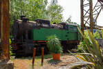 Etwas für Fotos ungünstig stehend, die Verschub-Dampflokomotive Emil Mayrisch 5, eine Krupp Bergbau, am 05 Juni 2011 im LWL-Industriemuseum Henrichshütte in Hattingen (bis 2007 WIM - Westfälisches Industriemuseum).

Die Krupp Typ Bergbau wurde 1953 Lokomotiv- und Waggonbaufabrik Krupp (LOWA) der Friedrich Krupp AG in Essen unter der Fabriknummer 3077 gebaut und als Lok IX an die Gewerkschaft Auguste-Victoria in Marl-Sinsen. Bis zu seiner Schließung 2015 war das Bergwerk das drittletzte aktive Steinkohlebergwerk Deutschlands sowie das zweitletzte im Ruhrgebiet.

1968 ging die Lok aber an die Grube Anna in Alsdorf des EBV - Eschweiler Bergwerks-Verein AG und wurde 1983 als ANNA Nr. 7 geführt, von 1983 bis zur Ausmusterung 1992 wurde die Lok  Emil Mayrisch 5  geführt. Im Jahr 1993 ging sie an das Bergbaumuseum Wurmrevier e. V. in Alsdorf und ging aber ende der 1990er an das damalige als geführt WIM - Westfälisches Industriemuseum, Standort Henrichshütte in Hattingen. 

Beschreibung des Typs  Bergbau  der Lokomotivfabrik Krupp (Essen):
Die normalspurige, vierachsige Tenderlokomotive war Teil des Nachkriegs-Typenprogramm Lokomotivfabrik in Essen und wurde sowohl in einer Naßdampf- als auch in einer Heißdampfversion geliefert. Zwischen 1948 und 1962 entstanden 30 Lokomotiven dieses Typs in der Lokomotivfabrik Krupp AG. Die  Bergbau  war nicht nur die leistungsstärkste, sondern mit Abstand mit 80 t die schwerste Maschine unter den Nachkriegsbauarten. 

Entstehungsgeschichte:
Während des Zweiten Weltkrieges erhielt Krupp den Auftrag zur Entwicklung einer schweren Dh2t-Lokomotivbauart für die Reichswerke Hermann Göring in Salzgitter, nach 1945 ging diese endgültig in der Salzgitter AG auf, die sich bis Ende der 1980er Jahre im Besitz der Bundesrepublik Deutschland befand. Nach Abschluss der Konstruktionsarbeiten wurde der Bau der 13 bestellten Maschinen kriegsbedingt zur Firma Werkspoor in Utrecht verlagert. Die Niederlande war ja von den deutschen Truppen besetzten worden. Bis zum Kriegsende konnte allerdings keine Lok fertig gestellt werden. Die angearbeiteten Baugruppen wurden kurz vor dem Abzug der Besatzungstruppen noch nach Essen überführt, wo sie nach Komplettierung und Endmontage ab 1948 zur ersten Serie der Bergbau wurden. 

Bauart:
Die Krupp Bergbau war für den schweren Übergabe- und Verschubdienst von Industrie- und Werksbahnen konzipiert. Entsprechend diesem Einsatzzweck war sie besonders robust und kräftig ausgeführt. Dank ihres vergleichsweise hohen Kesseldrucks, der großen Zylinder und des günstigen Übersetzungsverhältnisses war die mit vollen Vorräten 80 t schwere und rund 1.000 PSi starke Lok nicht nur die leistungsfähigste Type des Krupp-Industrielokprogramms, sondern die schwerste und stärkste vierachsige deutsche Tenderlok überhaupt. Im unteren Geschwindigkeitsbereich übertraf ihre Zugkraft sogar die der sechsachsigen Schlepptenderlok der Baureihe 50. Die zulässige Höchstgeschwindigkeit betrug 50 km/h. Zwecks Erzielung günstiger Kurvenlaufeigenschaften lagen nur der erste und dritte Radsatz fest im Rahmen, der zweite und vierte Radsatz waren jeweils um 15 mm seitenverschiebbar.

Die Type wurden in mehreren Baulosen gefertigt, die sich teilweise äußerlich unterscheiden lassen; die ersten beiden Serien besaßen viereckige Führerhausstirnfenster nach Art der Kriegslokomotiven, kantige Führerhausdächer und zwei sichtbare Kesselaufbauten (Dampfdom mit zwei Sandkästen unter gemeinsamer Verkleidung, separater Speisedom); später gebaute Loks hatten ovale Stirnfenster, abgerundete Führerhausdächer sowie eine durchgehende Verkleidung von Speisedom, Dampfdom und nur noch einem Sandkasten. Da sich der Wasservorrat von zunächst 8 m³ bei den auf der Hafenbahn der HOAG (Walsum – Oberhausen) eingesetzten Loks als etwas knapp erwiesen hatte, wurde ein Teil der später gebauten Maschinen mit vergrößerten hinteren Vorratsbehältern ausgerüstet. Der hintere Überhang wuchs dadurch um 150 mm, der Wasservorrat nahm auf 10 m³ zu. Einige Maschinen wurden ab Werk mit einem Mischvorwärmer ausgerüstet.

TECHNISCHE DATEN:
Gebaute Anzahl: 30
Baujahre: 1948 bis 1962
Bauart: D n2t oder D h2t
Spurweite: 1.435 mm (Normalspur)
Länge über Puffer: 11.100–11.250 mm (je nach Bauserie)
Höhe: 4.150 mm
Breite: 3.130 mm
Gesamtachsstand: 4.500 mm (3 x 1.500 mm)
Treibraddurchmesser: 1.200 mm (neu)
Dienstgewicht: 80 t
Höchstgeschwindigkeit: 50 km/h (vorwärts / rückwärts), diese zuletzt 25 km/h
Indizierte Leistung: 735 kW / 1.000 PS
Anfahrzugkraft: 223 kN
Kesselüberdruck: 15 bar
Zylinder: 2 (Ø 630 mm x 600 mm Hub)
Steuerungsart: Heusinger auβen
Rostfläche: 2,46 m² 
Überhitzerfläche: 42 m² 
Verdampfungsheizfläche: 118 m²
Wasservorrat: 10,0 m³
Kohlevorrat: 3 t
Kleinster bef. Halbmesser: 100 m
Bremse: Knorr 
