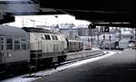 218 411-7 mit Nahverkehrszug fährt aus Um aus; vorn rechts rangiert eine 263, links steht ein Postwagen am Bahnsteig, am 15.10.1980.