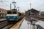 Die SNCF BB 22312  Antibes / Juan-les-Pins  (BB 5 22312R bzw. UIC: F-SNCF 91 87 0022 312-) hat am 25 März.2015 mit einem TER Regionalzug den Bahnhof Marseille-Saint-Charles erreicht. Es regnete Bindfäden. 

An Hand der ersten Ziffer vor der Loknummer (5), kann man die die Zugehörigkeit zum Geschäftsbereich der SNCF erkennen, die  5  steht für TER (Regionalverkehr). 
Mit der Aufgliederung der SNCF in verschiedene Geschäftsbereiche wurde der Bestand an Loks zum 1. Januar 1999 aufgeteilt, die Zugehörigkeit kann man an der ersten Ziffer erkennen:
1 = VFE (Fernverkehr),
2 = CIC (überregionaler Personenverkehr),
4 = Fret (Güterverkehr) und
5 = TER (Regionalverkehr).

Das  R  hinter der Loknummer zeigt dass diese Lok Wendezugtauglich ist. Ab 2006 wurden einige BB 22200 mit Wendezugsteuerungen versehen, zur Kennzeichnung, wurde wie bei dieser, der Loknummer das  R  (R = réversible) nachgesetzt. 

Die Lok BB 22312 trägt das Wappen der französischen Stadt Antibes / Juan-les-Pins, diese liegt an der Eisenbahnstrecke von Marseille nach Monaco (zwischen Cannes und Nizza) an der Côte d’Azu. Juan-les-Pins ist ein Seebad an der Côte d’Azur. Der Ort gehört zur Gemeinde Antibes und liegt im Département Alpes-Maritimes in der Région Provence-Alpes-Côte.

Die BB 22200 ist eine Zweisystemlokomotive für den Einsatz sowohl auf dem mit 1,5 kV elektrifizierten Gleichstromnetz der SNCF als auch auf dem mit 25 kV 50 Hz elektrifizierten Wechselstromnetz. In den Jahren 1976 bis 1986 wurden von Alsthom in sechs Bauserien insgesamt 205 Lokomotiven gebaut.

In den 1970er-Jahren benötigte die SNCF neue Mehrsystemlokomotiven, um unter beiden Stromsystemen ohne Lokwechsel fahren zu können. Aus der ab 1971 gelieferten Baureihe BB 15000 und der ab 1976 gebauten Gleichstrombaureihe BB 7200 wurde die BB 22200 als Mehrsystemvariante entwickelt. Die Baureihenbezeichnung bildet die Summe aus denen der beiden Schwesterbauarten.

TECHNISCHE DATEN:
Gebaute Stückzahl: 205
Hersteller: 	Alstom
Baujahre: 1976–1986
Spurweite: 1.435 mm (Normalspur)
Achsformel: B'B'
Länge über Puffer: 17.480 mm
Drehzapfenabstand: 9.694 mm
Achsabstand im Drehgestell: 2.800 mm
Triebraddurchmesser (neu): 1.250 mm
Dienstgewicht: 90 t
Höchstgeschwindigkeit: 160 km/h (wenige umgebaute 200 km/h)
Dauerleistung: 4.140 kW (bei 25 kV 50 Hz) / 4.040 kW (bei 1,5 kV CC)
Stromsystem: 25 kV/50 Hz AC, 1,5 kV DC
Anzahl der Fahrmotoren: 2 (TAB 674)
