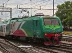 Lok E 464 901 zieht ihren Zug an ihrer Endstation aus dem Bahnhof von Ferrara auf ein Nebengleis.