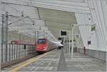 Während ein FS Trenitalia ETR 500 in der wunderschönen Halle des Bahnhofs von Reggio Emilia AV auf der Fahrt nach Norden kurz anhält; fährt kaum zu sehen links im Bild der bereits