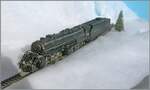 Die selbst in H0 mächtige Mallet Dampflok 2-8-8-2 - Y6b 2197 der Norfolk & Western kämpft sich durch den Schnee. Die Konstruktion der Mallet Vorbildloks Loks basiert Angaben, welche die U.S.R.A. (United States Raitroad Administration) während des Ersten Weltkriegs eingeführt hat. Die die Loks der Klasse Y6b wurde ab 1936 ausgeliefert. Grundsätzlich wurde die Klasse Y6b so konstruiert, dass sie schwere Güterzug mit 30 mp/h ziehen konnte, doch unter guten Bedingungen konnten auch bis zu 50 mp/h erreicht werden. 

Das Modell dieser Gelenklokomotive Typ Mallet „Y 6 b“ der  Norfolk & Western  dürfte gut 50 bis 60 Jahre alt sein und ist eine von der Grüsse her sehr beeindruckende Modellumsetzung. Nicht ganz logisch scheint mir, weshalb der Motor bei soviel Platz in das Führerhaus gequetscht wurde, um dann durch lange kardanischen Wellen die weit entfernten  Drehgestelle  anzutreiben. Der Tender ist vorbildgerecht mit zwei dreiachsigen  Buckeye -Drehgestellen ausgestattet, die auch zur Stromabnahme herangezogen werden. 

Das Modell dürfte gut zwanzig bis dreissig Jahre lang nicht mehr gefahren sein, nachdem ich das Modell zerlegt und bewegliche Teile entfettet und neu eingeölt habe, fährt es seit gestern wieder, auch wenn mir für den Auslauf des mächtigen Modell sowohl die Wagen als auch die Strecke fehlt. 

12. Jan. 2025