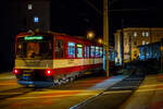 Der ET 51 „Berchtesgaden“ (Baujahr 1992) der SLB - Salzburger Lokalbahn hat am späten Abend des 12.09.2022 (21 Uhr) den Lokalbahnhof Salzburg verlassen  und fährt als S1 nach Lamprechtshausen, hier überquert er gerade die Fanny-von-Lehnert-Straße (Bü). 

Der Triebwagen wurde 1992 von SGP - Simmering-Graz-Pauker AG) gebaut, der elektrische Teil ist von AEG. Der Triebwagen wurde 2012/13 ebeim tschechischen Unternehmen INEKON in Ostrava mit einem zusätzlichen Niederflur-Mittelteil zum achtachsigen Fahrzeug umgebaut. Weiteres wurden in den Endwagen Sitze und Bodenbeläge getauscht sowie die Drehfalttüren durch Schwenkschiebetüren der Firma IFE ersetzt.

Die beiden Wagenkästen des Triebwagens stützen sich stirnseitig
über Schraubenfedern auf die Drehgestelle ab. Diese sind als Triebdrehgestelle ausgeführt, welche je einen Gleichstrommotor aufnehmen. Die Kraftübertragung erfolgt mittels starrer Wellen und Achsgetrieben auf beide Achsen eines Drehgestells. Jede der acht Achsen ist mittels Maggy-Federn mit dem Drehgestell verbunden. Jede Achse der Triebdrehgestelle wird mit Federspeicherbremsen gebremst. Als primäre Betriebsbremse dient eine elektrische Bremse, als Zusatzbremse dienen Magnetscheibenbremsen an jedem Drehgestell. Die Laufdrehgestelle werden mit Druckluftbremsen gebremst.

Durch entsprechende elektronische Ansteuerung können die Triebwagen in Vielfachsteuerung (max. drei Fahrzeuge) eingesetzt werden.

Bemängelt wird von den Fahrgästen, dass der gesamte Triebewagenbestand auch im Zuge der letzten Modifizierungen noch mit keiner Klimaanlage versehen wurde

Mechanischer Teil
Der Wagenkasten ist als selbsttragende Stahlkonstruktion ausgeführt welche sich auf den beiden Motordrehgestellen an den Fahrzeugenden sowie auf Jakobs-Drehgestelle abstützt. Der Fahrmotor ist den Drehgestellen als Längsmotor eingebaut, die Kraftübertragung erfolgt über Winkelgetriebe (Tandemantrieb). Die Primärfederung wurde mittels Megi-Federn ausgeführt, zwischen Drehgestell und Wagenkasten kommen Schraubenfedern in Verbindung mit hydraulischen Stoßdämpfern zum Einsatz. Die Wagen 50–58 wurden in den Jahren 2012–2014 um ein Niederflur-Mittelteil erweitert und ein zusätzliches Jakobs-Drehgestell erweitert. Des Weiteren wurden in den Endwagen Sitze und Bodenbeläge getauscht sowie die Drehfalttüren durch Schwenkschiebetüren der Firma IFE ersetzt. Das Umbauprogramm wurde 2019 mit dem ET46 abgeschlossen. Somit sind von den 18 Triebwagen insgesamt 13 mit Mittelteil (ET46-ET58, Bezeichnung ET40NF) ausgestattet und 5 Fahrzeuge (ET41-ET45) noch wie ursprünglich 2-teilig. 

Elektrischer Teil
Die Fahrmotoren sind als vierpolige, kompensierte Vollspannungs-Reihenschlussmotoren mit 300 kW Nennleistung ausgeführt. Jeder Motor wird von einem eigenen Thyristor-Gleichstromsteller (Chopper) angesteuert. Durch die Verwendung von Gleichstromstellern ist es möglich, Bremsenergie in die Fahrleitung zurück zu speisen. Kann die Bremsenergie nicht aufgenommen werden, wird diese durch Bremswiderstände in Wärme umgewandelt. 

TECHNISCHE DATEN:
Gebaute Anzahl: 9 (ET 46 bis ET 58)
Spurweite:  1.435 mm (Normalspur)
Achsfolge:  B‘2‘2‘B‘
Länge über Puffer: 38.800 mm
Höhe mit Dachaufbauten: 3.720 mm
Breite: 2.674 mm
Fußbodenhöhe über SOK: 984 mm, im Niederflur-Mittelteil 350 mm
Leergewicht: 62.700 kg
Drehzapfenabstand: 3 x 10.400 mm
Achsstand im Drehgestell: 1.900 mm
Raddurchmesser:  780 mm (neu) / 710 mm (abgenutzt)
Kleinster zulässiger Bogenradius:  80 m
Höchstgeschwindigkeit: 80 km/h
Sitzplätze: 104
Stehplätze: 158
Leistung Fahrmotoren:  2 x 300 kW 
Übersetzung: 1:5,625
Stundenleistung:  600 kW
Fahrdrahtspannung : 1.000 V DC (=)
Steuerung:  Chopper (Gleichstromsteller)
Stromabnehmer:  Halbscherenstromabnehmer
Zug- und Stoßvorrichtung: Scharfenbergkupplung
Bremsbauart: Elektrodynamische Nutzbremse, Federspeicher-, Magnetschienen- und Solenoidbremse

Quelle: SLB