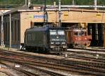 . Aus dem Archiv - Am fr�hen Morgen des 06.08.2007 sonnten sich schon zwei Loks am BLS D�pot in Brig, rechts eine BLS Ae 8/8 und links die RTS 185 569-1. Das Foto entand am Bahnsteig. (Hans)