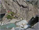 W�hrend die Strecke der MGB behutsam und schachte ins Talhinunter geht und hier im Tunnel verschwindet, tost das Wasser der Reuss den Abhang hinunter, zur Teufelsbr�cke, die am rechten Bildrand zu