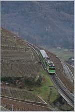 Der BDeh 4/4 313 mit seine Bt 363 auf der 230 Promiller Rampe oberhalb von Aigle wird in wenigen Minuten den Talboden erreichen.