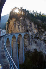 UNESCO-Weltkulturerbe Albulabahn: 
Geführt von der weißen RhB Ge 4/4 III («BoBo 3») – 643  Vals  mit Werbung für die Ems-Chemie, fahren wir am 06.09.2021, mit dem IR (Chur - St. Moritz) der Rhätischen Bahn (RhB), nun über berühmten, 136 m langen und 65 m hohen, Landwasserviadukt bei Filisur.