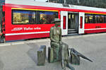 Hier aus der Sicht von Herbert (Foto Herbert Graf), die „wartende Reisende von Thusis“ vom Bildhauer Robert Indermaur und dahinter zwei auf die Abfahrt wartende Reisende in einem Alvra-Gliederzug, am 21.03.2023 im Bahnhof Thusis, wo die Albulabahn beginnt.