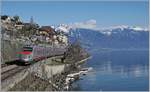 Ein FS Trenitalia ETR 610, als EC 34 von Milano nach Genève unterwegs zeigt sich bei St-Saphorin vor dem Hintergrund des malerischen Ortes und der noch von Schnee bedecken Berge.