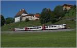 Der TPF RABe 567 182 ist bei Vaulruz auf dem Weg nach Bulle vor dem Hintergrund schmucker Geb�ude des Ortes.