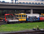 Der tschechische Schwerlastkleinwagen mit Kran MUV 77 – 009 (CZ-SŽCZ 99 54 9628 799-7, ex CZ-SŽDC 99 54 9628 799-7) der Správa železnic steht am 24.11.2022 bei Praha-Smichov. Davor der zweiachsige (leider beschmierte) Bauwagen PV-69 (CZ-SŽCZ 49 54 9400 402-3).

Das staatliche tschechische Eisenbahninfrastrukturunternehmen hieß bis Januar 2020 SŽDC - Správa železniční dopravní cesty (deutsch: Verwaltung der Eisenbahn-Verkehrswege) und wurde Správa železnic (SŽCZ) unbenannt.

MUV 77 ist die Typenbezeichnung eines neueren Schwerlastkleinwagens die bei tschechischen Eisenbahnen als Gleisarbeitsfahrzeug mit Plattform und hydraulischen Kran eingesetzt werden. Gebaut bzw, umgebaut wurden vie von TSS (Traťová strojní společnost, a.s.)

TECHNISCHE DATEN vom MUV:
Hersteller: TSS (Traťová strojní společnost, a.s.)
Baujahr: 2012
Spurweite: 1.435 mm (Normalspur)
Achsformel:  B'
Länge über Puffer: 7.670 mm
Achsabstand: 4.200 mm
Eigengewicht: 11.115 kg
Nutzlast: 5.000 kg
Dieselmotor: wassergekühlter 4-Zylinder-Reihenmotor mit Turboaufladung und Ladeluftkühler vom Typ Deutz TCD 2012 L04 2V
Motorhabraum: 4,04 Liter (Bohrung 101 mm / Hub 126 mm)
Max. Drehmoment: 520 Nm bei 1.600 U/min 
Niedrigste Leerlaufdrehzahl: 650 U7min.
Motorgewicht (trocken): 400 kg
Leistung: 96 kW
Höchstgeschwindigkeit: 70 km/h
Kleister befahrbarer Gleisbogen: R 90 m
Kran: FASSI, Typ F 80 (max. Lastmoment 77 kNm)

TECHNISCHE DATEN vom Wagen:
Achsen:  2
Länge über Puffer: 5.530 mm
Achsabstand: 3.500 mm
Eigengewicht: 4.370 kg
Nutzlast: 3.200 kg
Ladefläche: 11,74 m²
Höchstgeschwindigkeit: 40 km/h
Kleister befahrbarer Gleisbogen: R 90 m
Handbremse: Ja
